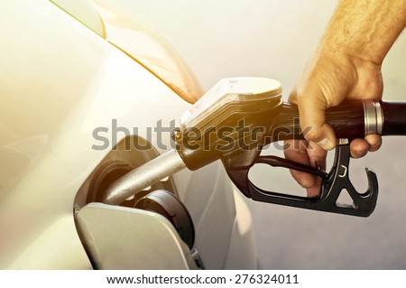 Close-up of a mens hand refilling the car with a gas pump