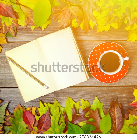 Colorful autumn background with autumnal leaves book and coffee cup