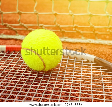 Tennis racket with ball on it clay on clay court