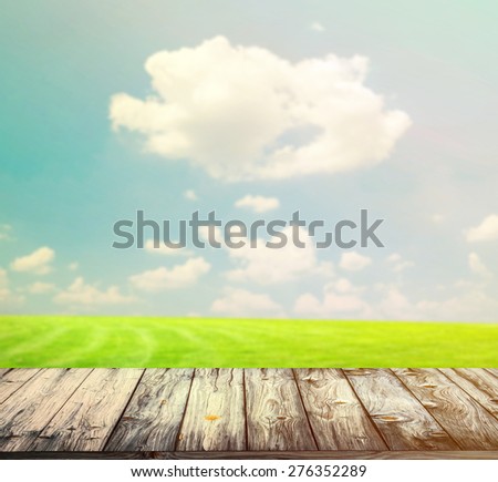 Background with empty wooden table over beautiful meadow