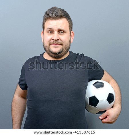 Portrait of chubby man holding football - Football fan supporter or player concept