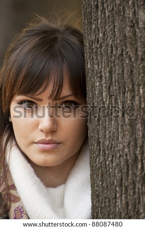 Woman portrait outdoors leaning on a tree