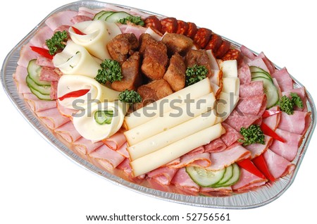 Salami and cheese rolls with vegetables on a plate isolated on white