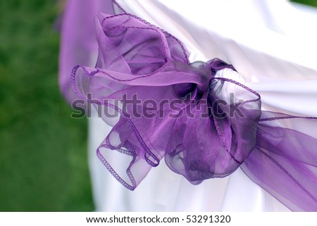 stock photo Violet wedding ribbon on white and green