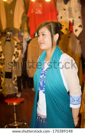 Shopping arcade in the old town of Chongqing, girl - the seller of clothes ...