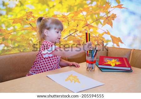 Portrait of little girl with pencils, colorizing maple leaves...