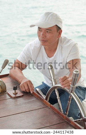 Photo of the man on watch sailor at the helm