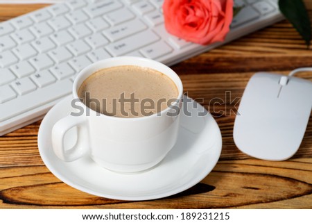 Close-up of the coffee, cellphone, pen and a cup of keyboard on the desktop