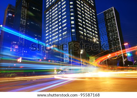 The traffic light trails in the street by modern building
