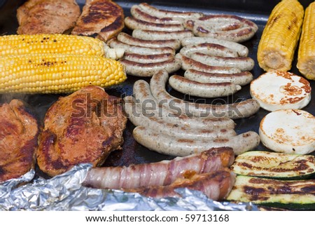 Grilled meat, sausage, corn, zucchini and halloumi on gas grill