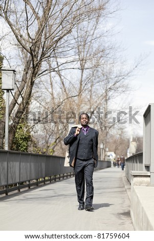 Successful black business man walking on street