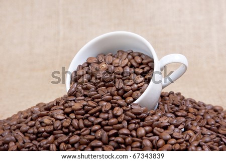 Coffee mug over the raw beans