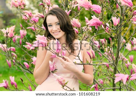 Outdoor portrait of happy young natural beauty woman in spring flowers