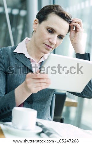 Business woman checking news at digital tablet in airport business lounge