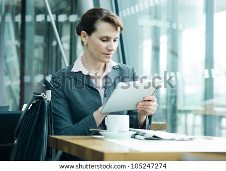 Business woman checking new on digital tablet at the airport business lounge