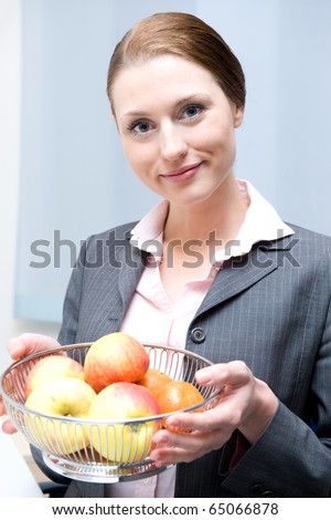 Business women holding a basket with fruits in the office