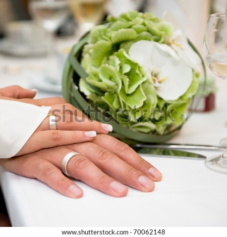 stock photo Hands with wedding rings in white gold and wedding flower 