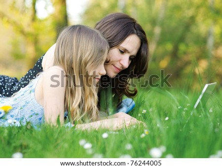 Girl and mommy working on notebook computer