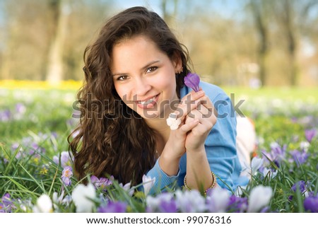 Young natural beauty woman is lying in spring in meadow