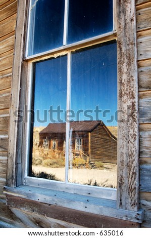 View of a ghost town reflected in an old window.