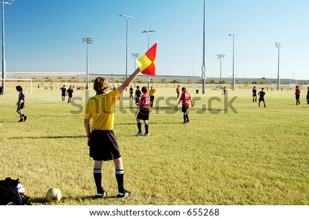 A soccer official signals a ball out of bounds.