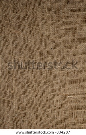 The course weave of burlap material. Close view, vertical.