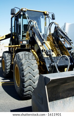 A front end loader staged for a new construction project in a suburban area.