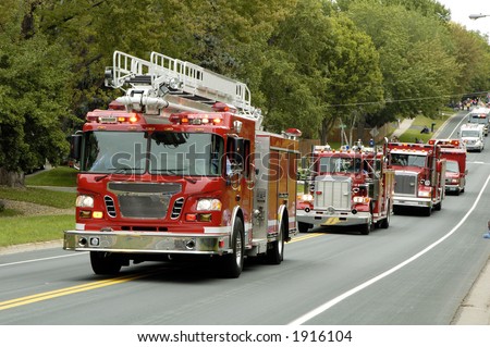 Fire and rescue vehicles being driven in a fire muster parade.
