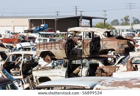 old vehicles in an auto salvage yard being recycled for parts and scrap metal