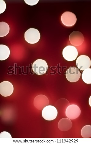 Bokeh lights with rich red background blending into darkness, portrait orientation.