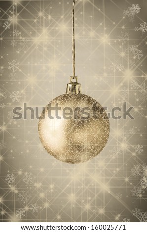 Photograph of a gold bauble, layered with twinkling glitter and sparkling stars against vignetted parchment background scattered with shining gold stars and snowflakes.