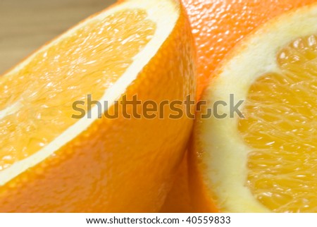 Three parts of an orange in close up (macro), on beech wood table.