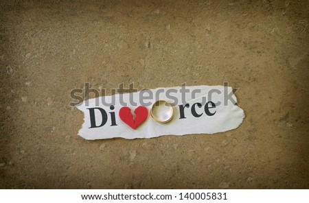 Paper scrap with Divorce text, wedding ring and red broken heart