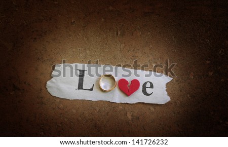 Love spelled with a gold wedding ring and red broken heart