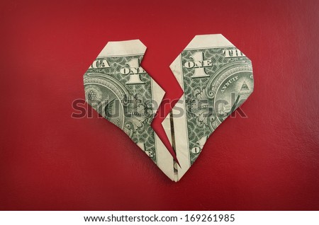 A broken origami dollar heart, on red