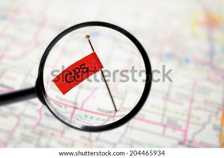 pin with stuck into a GPS map with magnifying glass