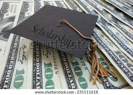 Mini graduation mortar board with Scholarship text, on money