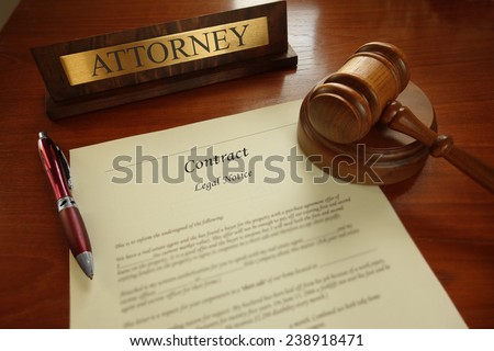 Legal contract with gavel and Attorney name plate on a desk