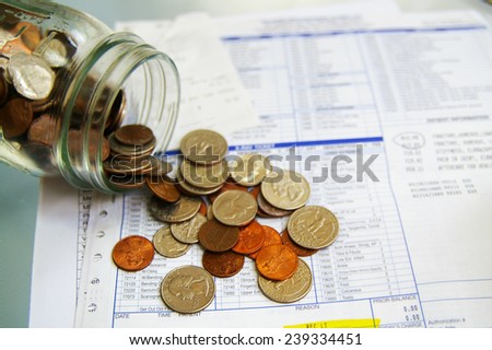 Hospital medical bills and spilled coins from a jar
