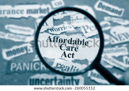 News headlines and magnifying glass with Affordable Care Act text
