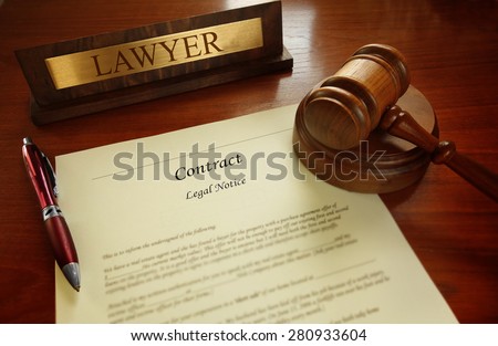 Legal contract with gavel and Lawyer name plate on a desk