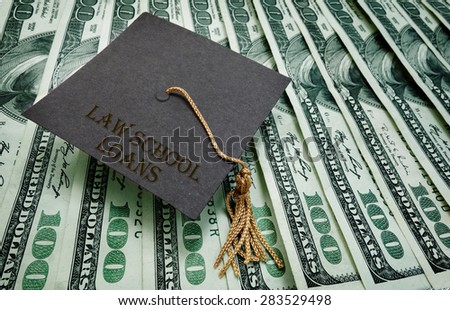 Law School Loans graduation cap on assorted hundred dollar bills - student loan concept