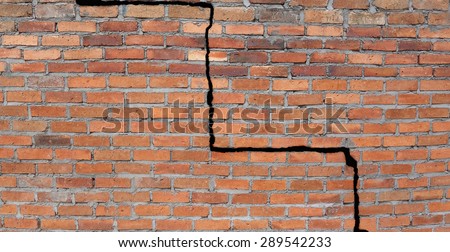 Large crack in a brick wall building foundation