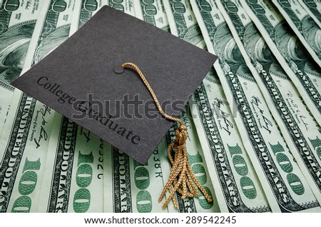College Graduate cap on assorted hundred dollar bills