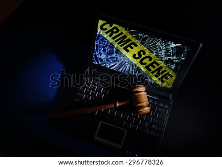 Judge\'s court gavel on a laptop with crime scene image on broken screen