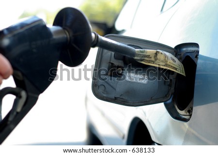 Money into the gas tank, representing the high cost of fuel