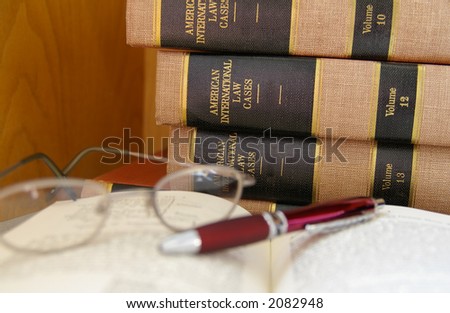 Law books stacked with glasses and pen