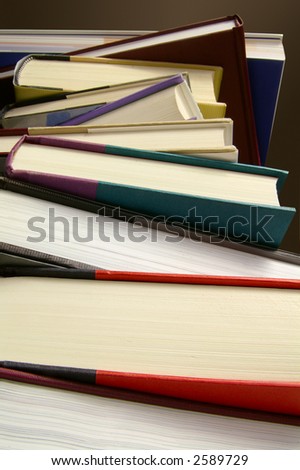 Stack of assorted hard-cover books shot from below