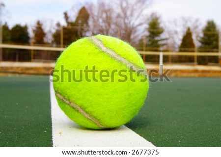 Closeup of a tennis ball on the boundary line
