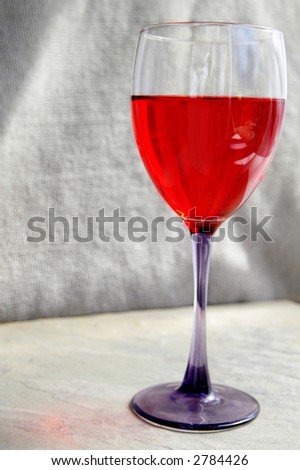 Glass of red wine on neutral textured background